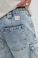 Bermuda cargo de jean color azul con lavado de efecto desgastado, corte amplio y bolsillos laterales con solapa.