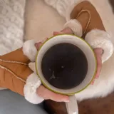 Guantes mitones negros de cuero con interior de piel sintética.