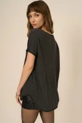 Remera blanca de poliéster y algodón, con escote en V, corte relajado, bordes sin rematar, detalles de costura central expuesta y dobladillo estilo camisero.