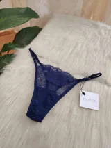 Microtanga de encaje azul con diseño floral, laterales regulables y forro de algodón.