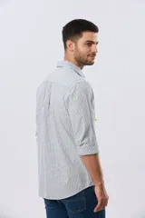 Camisa de lino rayada de manga larga, con cuello camisero, cierre frontal de botones y bordado sutil en el pecho.