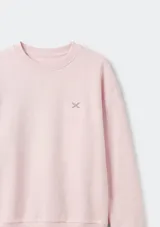 Buzo de cuello redondo con mangas largas y puños elásticos. Presenta un pequeño bordado en el pecho y un diseño liso en color rosado.