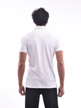 Remera polo blanca de corte regular, con cuello clásico, tapeta de dos botones y bolsillo de parche en el pecho.