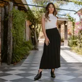 Botín de cuero vacuno color marrón oscuro, con taco de madera foliado en cuero de 5cm de altura, cierre lateral interno y horma de punta fina.