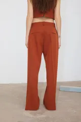 Pantalón de vestir color ladrillo, de corte recto con bolsillos laterales y tajo en el ruedo.