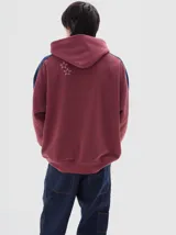 Hoodie de felpa con frisa suave, color negro, con calce oversized y franjas laterales en contraste.