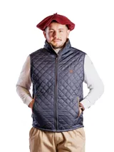 Chaleco negro capitoneado e impermeable, con cierre frontal y cuello alto.