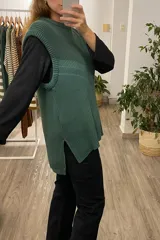 Chaleco tejido verde con tajos laterales.