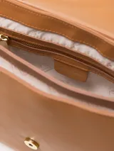 Cartera bandolera de cuero color caramelo, con cierre de candado dorado, doble correa de hombro y forro interior de poliéster con dos divisiones.