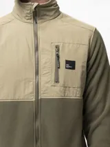 Campera de polar negro con paneles de nylon en el pecho, cuello alto, cierre frontal completo, bolsillo con cierre en el pecho y bolsillos laterales con cierre.