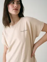 Camisón blanco de algodón, de corte holgado, manga corta y largo por encima de las rodillas. Presenta una pequeña estampa localizada en el pecho y aberturas en los laterales.