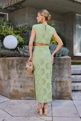 Falda midi color lima con diseño calado de abanicos, de corte recto y tiro alto.