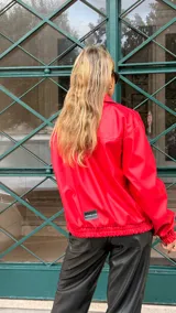 Campera de cuero sintético color rojo, con cierre frontal, cuello camisero y puños elásticos.