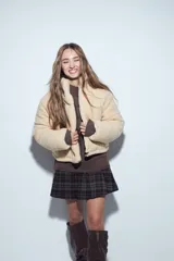 Campera puffer de corderito negro con cuello alto y diseño oversized. Presenta una textura tipo teddy, cierre frontal y corte a la cintura.