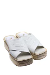 Zueco con plataforma de madera y capellada de cuero negro con textura croco.