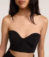 Blusa super cropped de sastrería color negro, con escote corazón y cierre trasero con cremallera.