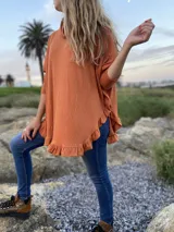 Polerón blanco de morley con cuello alto y volados en ruedo y puños.