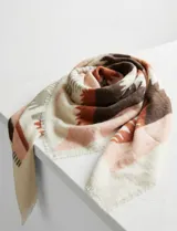 Pashmina o chal de tejido grueso, con diseño geométrico en bloques de color. Predominan los tonos crema, verde oscuro, marrón y negro. Presenta bordes deshilachados.