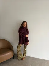 Pantalón tipo oxford de tiro alto, con estampado abstracto en tonos tierra, negro y crema. Presenta un corte ajustado en la parte superior y acampanado desde la rodilla hacia abajo.