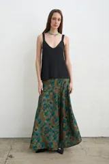 Falda larga irregular de seda con estampado en tonos marrón y verde, corte evasé y caída fluida.