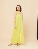 Vestido largo blanco de lino con escote en V y flecos de algodón en los bordes.