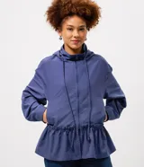 Campera cortaviento de poliéster color azul, con diseño peplum en la cintura, capucha ajustable con cordones y cierre frontal. Presenta mangas largas y un corte funcional y liviano.