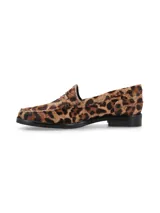 Mocasín de cuero con pelo y estampado animal print de leopardo, con silueta clásica, costuras visibles en el empeine y suela plana de goma con pequeño tacón.