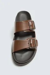 Sandalia negra de dos tiras anchas ajustables con hebillas metálicas cuadradas. Presenta una plantilla anatómica y suela plana a tono.