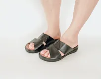 Sandalia de cuero negro con textura de reptil, diseño de tiras cruzadas con ajuste de velcro y suela de poliuretano con plataforma.