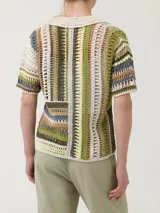 Sweater de crochet modelo Lenka, confeccionado con mezcla de algodón orgánico y lino. Presenta diseño de rayas verticales en la parte superior y horizontales en la inferior, con cuello camisero, mangas cortas y cierre frontal de botones.