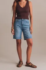 Bermuda de denim de tiro alto, corte recto y ajuste holgado, con diseño clásico de cinco bolsillos y lavado azul medio.