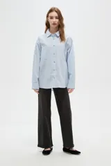 Camisa de algodón con estampado de rayas verticales finas, cuello camisero, cierre frontal con botones y bolsillos frontales tipo parche.