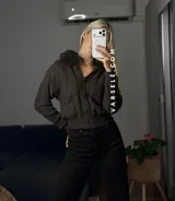 Saco tejido de punto con diseño de ochos, cuello con detalle de piel sintética, cierre frontal con botones al tono y mangas largas.