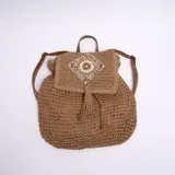 Mochila marrón de yute con solapa con diseño bordado y flecos.
