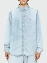 Camisa de jean celeste claro Diesel modelo D-Simply, de corte recto, manga larga, cuello clásico y cierre frontal con botones metálicos. Presenta un pequeño logo rojo bordado en el pecho.