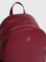 Mochila Tommy Hilfiger color rojo con detalles en azul marino. Tiene asa superior, dos correas ajustables, logo monograma metalizado de TH y cierre con cremallera.