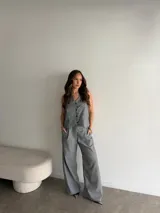 Conjunto de lino gris con diseño a rayas verticales, compuesto por un chaleco sin mangas con botones frontales y un pantalón largo de corte amplio.