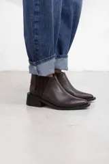 Botineta de cuero negro con textura sutil, con elásticos laterales y taco cuadrado bajo.