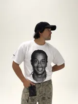 Remera blanca de corte boxy y diseño oversize, con estampa fotográfica frontal en blanco y negro del futbolista Ronaldinho.