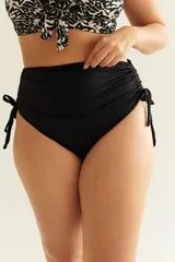Bombacha de bikini tiro alto color negro, con frunce regulable en los costados y forro interior delantero. Confeccionada con tela que contiene fibra LYCRA® XTRA LIFE™.