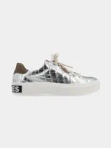 Sneaker de plataforma color plata con textura efecto cocodrilo, detalle de gamuza marrón en el talón y suela blanca con inscripción en el lateral.
