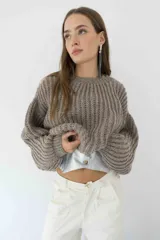 Sweater tejido color beige con cuello redondo y mangas abullonadas.