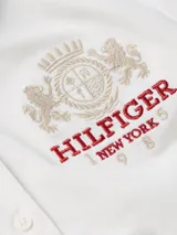 Chomba blanca de corte slim fit, con cuello polo, cartera de cuatro botones y logo bordado en el pecho.