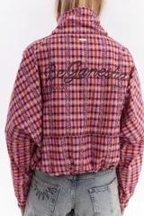 Chaqueta bomber de algodón con estampado a cuadros en tonos azules, amarillos y marrones, cuello alto y cierre frontal descentrado con botones. Cuenta con mangas abullonadas y puños elásticos.