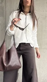 Sweater de hilo color blanco con cuello redondo y diseño de bordados florales en relieve en el frente.
