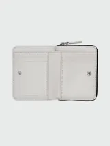 Billetera compacta Marc Jacobs modelo The Wild Daisy Mini Compact, de cuero blanco con estampado de flores de colores. Incluye cierre con cremallera, múltiples ranuras para tarjetas y logo de la marca en el frente.