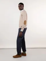 Sweater color beige de punto fino, con cuello en V y logo bordado en el pecho.