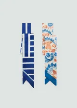 Pack de dos pañuelos de tela fluida con diseño alargado. Uno presenta un estampado geométrico de rayas azules y blancas, mientras que el otro cuenta con un estampado floral en tonos azules y naranjas sobre fondo blanco.