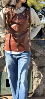 Sweater de diseño artesanal con frente de cuero marrón y mangas y espalda tejidas en lana color beige. Presenta detalles de bordados a mano en forma de cruz a lo largo de las costuras laterales y el escote.