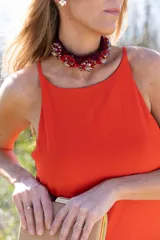 Gargantilla de cordón tejido en tono bordó, decorada con abalorios y cuentas facetadas en tonos rojos y dorados.